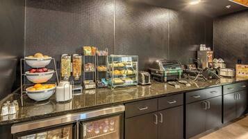 Un buffet proposant une variété de plats, un grille-pain et un réfrigérateur.