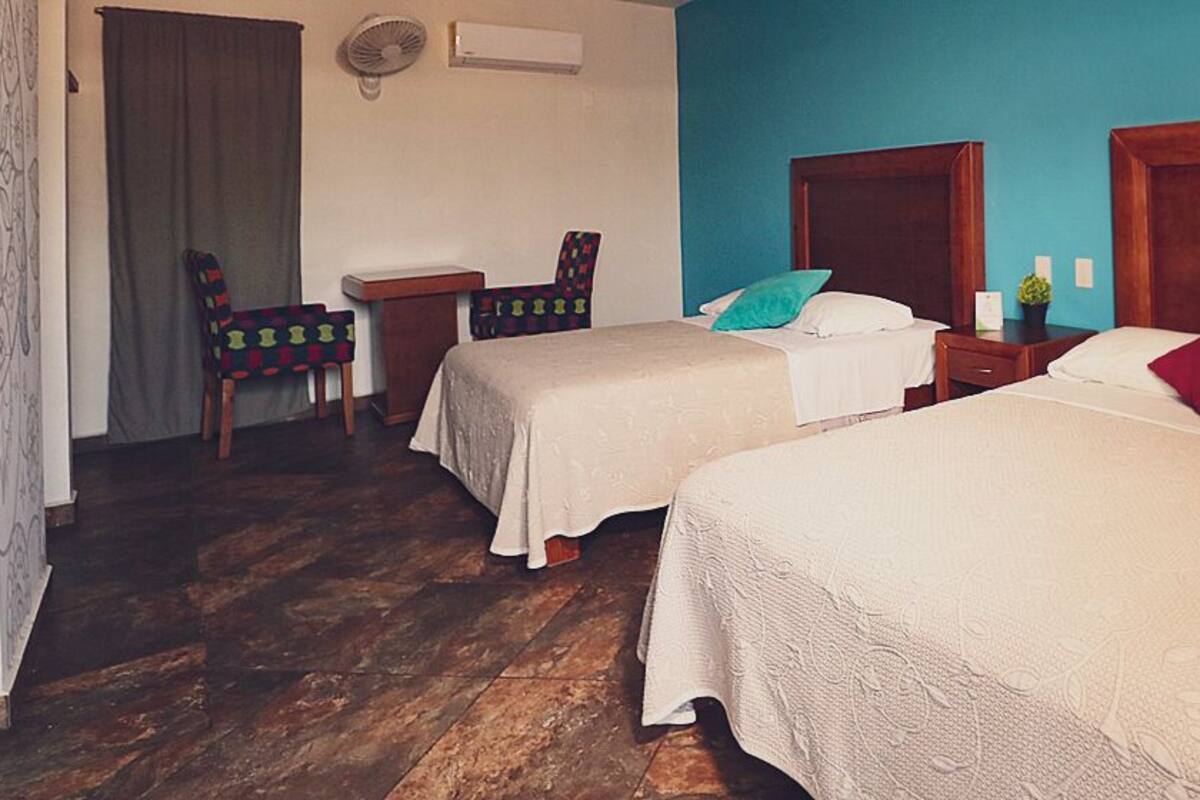 Een kamer met twee bedden, een bureau en een stoel.