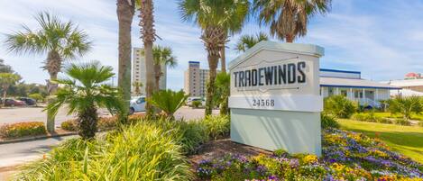 A sign for 'Tradewinds' with a number '24568' and a building in the background.