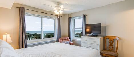 Une chambre à coucher avec un lit, une chaise, une télévision et une commode.