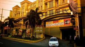 A hotel with multiple floors, balconies, and a sign indicating Wi-Fi availability. - Jardin de Rosal Hotel (Pasig)