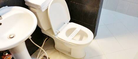 A bathroom with a toilet, sink, and tiled floor.