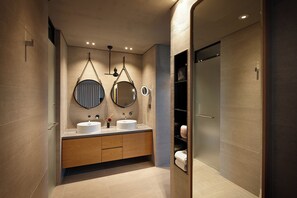Une salle de bain moderne avec deux lavabos, un meuble-lavabo et une douche à l’italienne.