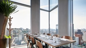 A high-rise dining area with a city view, large windows, and modern furnishings. - L7 HONGDAE by LOTTE HOTELS (Seoul)