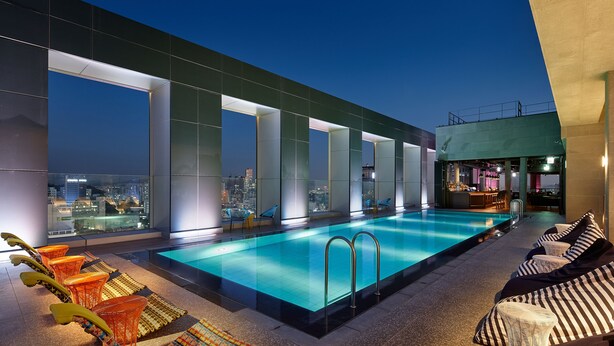 A rooftop pool area with a city view, lounge chairs, and a bar. - L7 HONGDAE by LOTTE HOTELS (Seoul)
