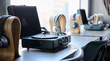 A turntable on a table with headphones and a speaker.