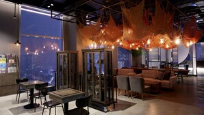 A modern interior with a dining area, seating, and a view of the cityscape. - L7 HONGDAE by LOTTE HOTELS (Seoul)