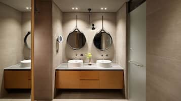 A modern bathroom with two sinks, wooden cabinets, and a mirror.