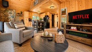 Ein gemütliches Blockhauss-Interieur mit Wohnbereich, Küche und Essbereich.