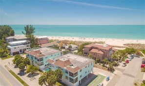 Une zone résidentielle côtière avec des bâtiments, une plage et un ciel dégagé.