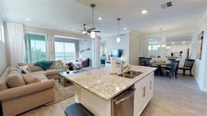 Enjoy a spacious living area with a sofa and dining table, a well-equipped kitchen, and a balcony with city views.