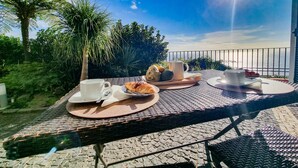 Ein Frühstückstisch mit Croissants, einer Karaffe und einer Tasse, mit Blick auf eine schöne Aussicht.