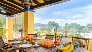 A dining table set with plates, cutlery, and a variety of fruits and pastries.