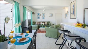 Un espacio habitable compacto con comedor, sofá y kitchenette.
