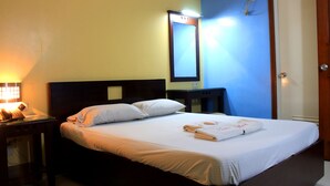 A hotel room with a bed, bedside table, nightstand, and a mirror on the wall. - Vista Apartelle & Restaurant (Makati)