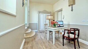 Un couloir qui comprend un coin repas avec une table, des chaises et une lampe.
