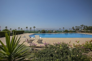 Piscine extérieure, parasols de plage, chaises longues