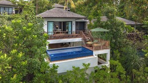 A two-story house with a swimming pool on the ground floor, surrounded by dense greenery. - The Residence Bintan (Bintan)