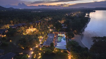 Un resort con varias construcciones, piscina y acceso directo a la playa.