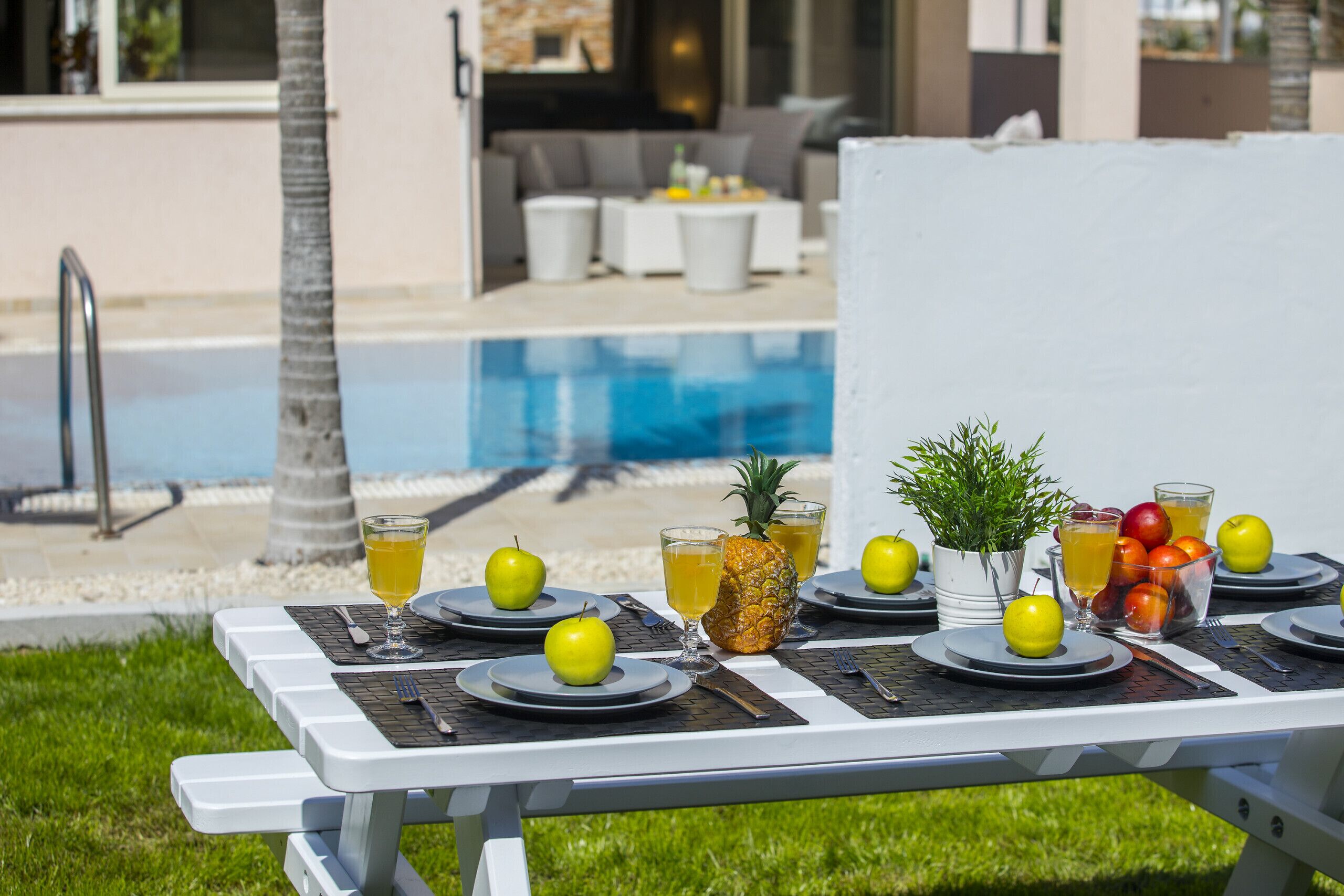 A poolside dining setup with tables, chairs, and a pool in the background.