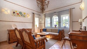 Ein Zimmer mit einer Holzsofa, einem Holztisch, einem Holzschrank und einer Zierdecke.