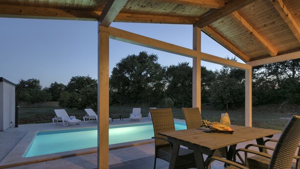 An outdoor pool area with a covered patio, lounge chairs, and a dining table. - Noelene - Cozy house, Private Pool, BBQ, Quiet area, Privacy (Valtura)