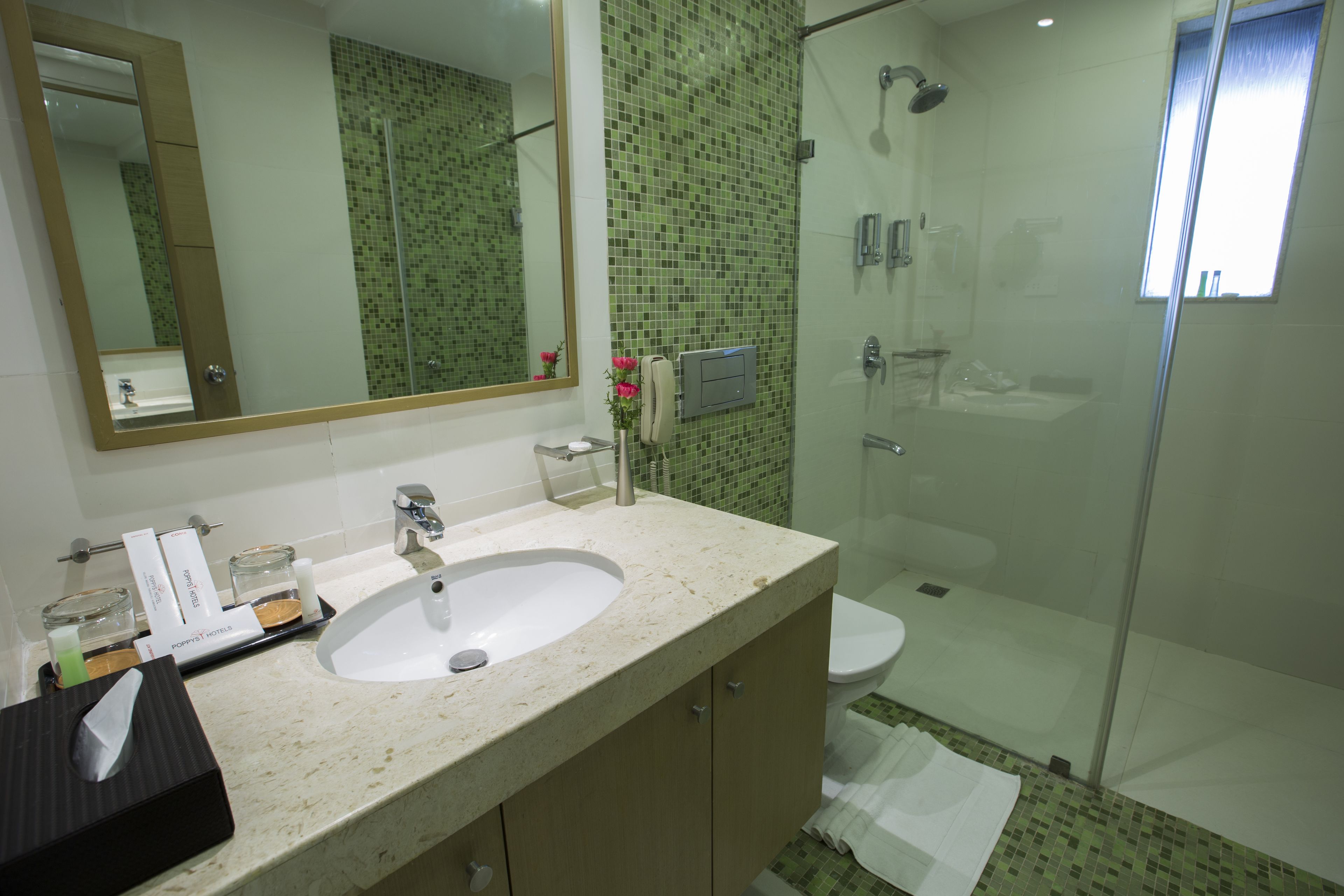 A bathroom with a sink, mirror, and shower.