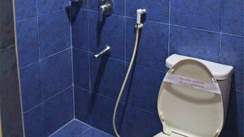 Een badkamer met toilet, douche en afvoer.