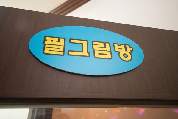 A blue sign with yellow text on a brown background.