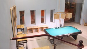 A pool table in a room with benches and a glass railing. - Ha Giang Amazing Hostel (Ha Giang 2)