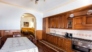 A kitchen with wooden cabinets, a gas stove, and a dining area with a table and chairs.