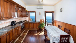 A kitchen with wooden cabinets, a stove, and a dining area with a table and chairs.