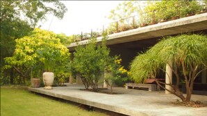 A concrete pathway with potted plants and a bench. - Uncle Jo Ranch (Pak Chong)