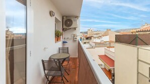A balcony with a table and chairs, a potted plant, and an air conditioning unit. - APARTMENT IN SANT ANTONI DE CALONGE 17 METERS FROM THE BEACH (Sant Antoni de Calonge)