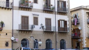 Een meerhoog gebouw met balkons, airconditioning en schotels.