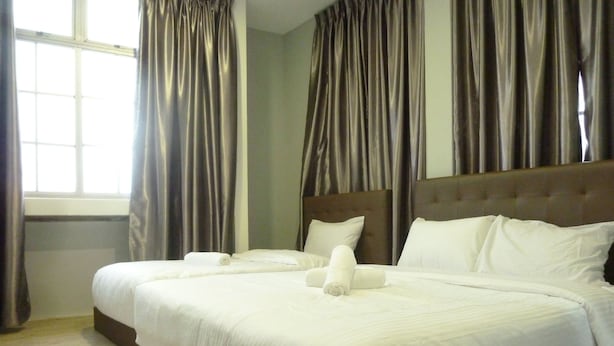 A hotel room with a large bed, two pillows, and a neatly made bedspread. - The b'Hotel Kajang (Kajang)
