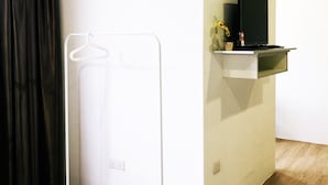 A room with a white wardrobe, a black TV on a shelf, and a wooden floor. - The b'Hotel Kajang (Kajang)