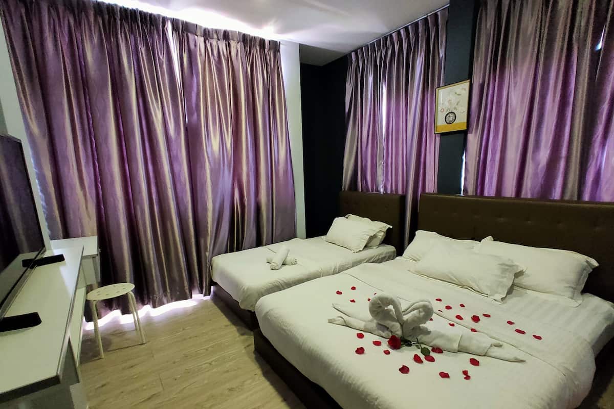 Quarto de hotel com duas camas, uma escrivaninha e uma cadeira.