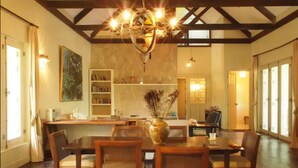 Un comedor con muebles de madera, una araña y una estantería.