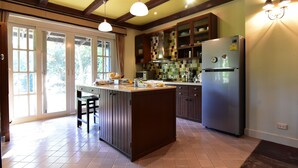 Una cocina con una isla central, armarios de madera y un refrigerador integrado.