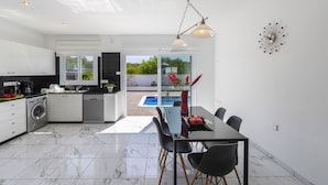 Una cocina moderna con comedor, vistas al exterior y piscina.
