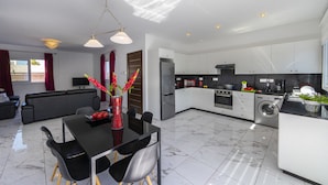 Una cocina moderna con comedor, sofá y televisor.