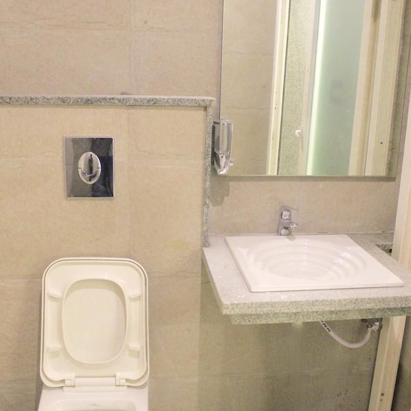 Un baño con inodoro, lavabo y espejo.