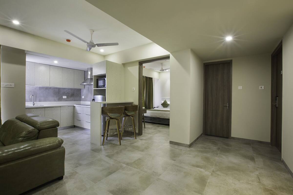 A modern apartment with a kitchen, dining area, and a bedroom.
