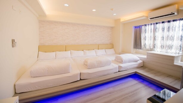 A modern bedroom with a large bed, a built-in massage table, and a small pool area. - FengJia Pandola (Taichung)