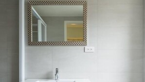 A bathroom with a white sink, a mirror with a patterned frame, and a toilet. - FengJia Pandola (Taichung)
