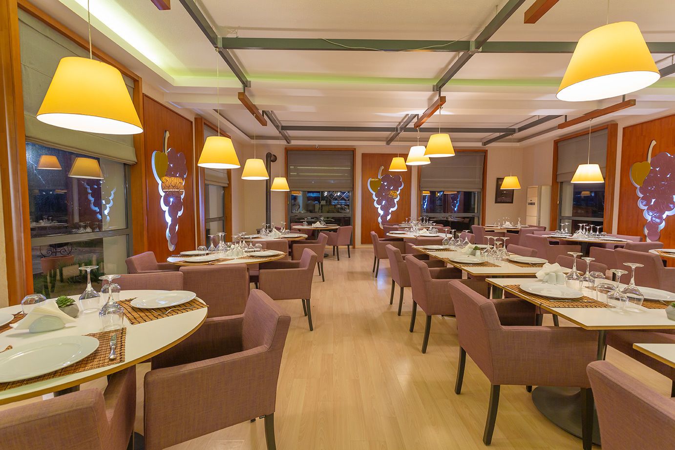 Ein Restaurant mit mehreren Tischen und Stühlen, an jedem Tisch Geschirr, Gläser und Besteck.