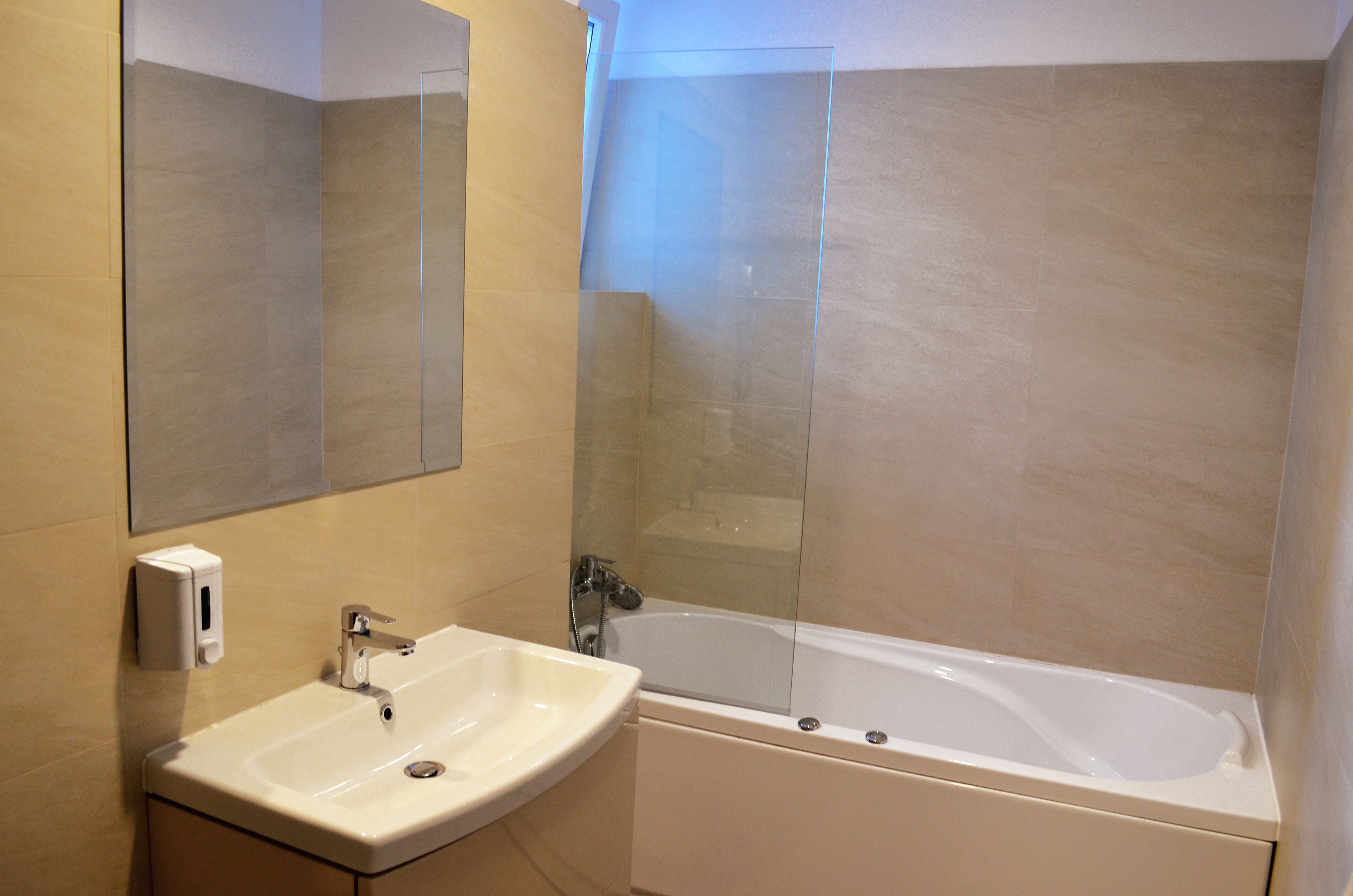 Une salle de bain avec un lavabo, un miroir et une baignoire.