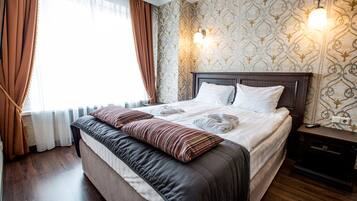 Junior-sviitti | Ylelliset vuodevaatteet, tallelokero huoneessa, työpöytä