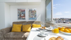 A hotel room with a sofa, breakfast table, and cityscape view. - Central Lisbon Apartment near Príncipe Real & Avenida da Liberdade - TTL308 (Lisboa ciudad)